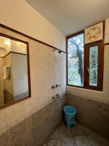 een badkamer met een blauw toilet en een raam bij Villa Bliss Lake View in Nainital