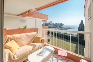 een bank op een balkon met uitzicht op de oceaan bij Apartment Boulouris in Saint-Raphaël