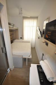 a small room with two beds and a television at Habitación el Camarote de El Vinagrillo con parking cubierto incluido in Cartagena