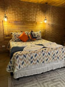 1 dormitorio con 2 camas y 2 luces en Pousada Recanto Ninho Verde Chalés, en Campos do Jordão