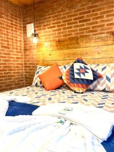a bed in a room with a brick wall at Pousada Recanto Ninho Verde Chalés in Campos do Jordão