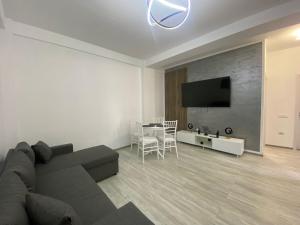 a living room with a couch and a table with chairs at Apartament Amy 2 in Mamaia Sat/Năvodari