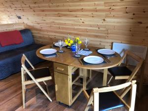 a wooden table with plates and glasses on it at Manor Farm Stay in Sutton on Sea