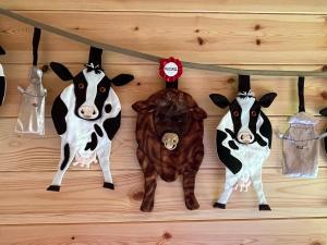 four fake cows hanging on a wall with clothes pins at Manor Farm Stay in Sutton on Sea