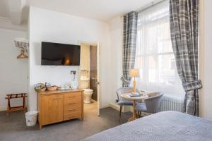 a bedroom with a bed and a desk and a table at The Black Swan Inn in Pickering