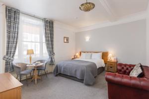 a bedroom with a bed and a table and a couch at The Black Swan Inn in Pickering