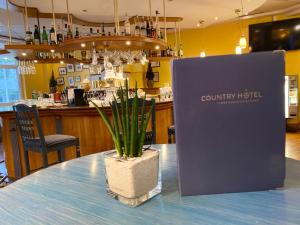a potted plant sitting on a table in a restaurant at Country Hotel Timmendorfer Strand in Timmendorfer Strand