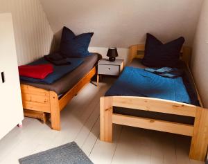 Zimmer mit 2 Betten und einer Lampe auf einem Tisch in der Unterkunft Haus am See mit Steg, Boot, Kamin und Sauna - Mecklenburgische Seenplatte in Blankensee