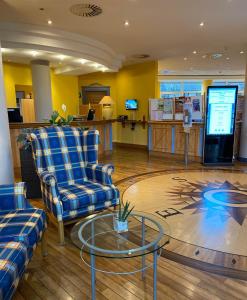 a lobby with two chairs and a glass table at Country Hotel Timmendorfer Strand in Timmendorfer Strand