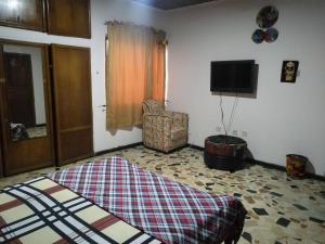 a living room with a rug on the floor and a chair at Room in House - Vals Residence O9o98o58ooo in Lagos