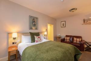 a bedroom with a bed and two chairs in it at The Black Swan Inn in Pickering