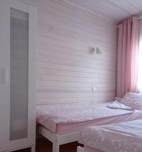 a bedroom with two beds and a pink wall at Strefa Kampinos in Brochów