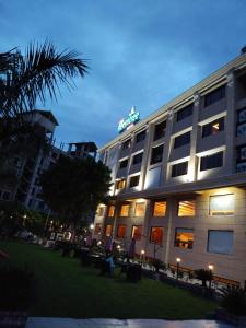 un edificio de hotel con un cartel encima en Sai Neem Tree Hotel, en Shirdi