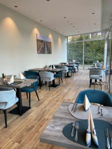 a dining room with tables and chairs and windows at Country Hotel Timmendorfer Strand in Timmendorfer Strand