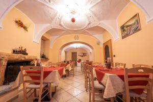um restaurante com mesas e cadeiras num quarto em Albergo Casavecchia em Tiarno di Sopra