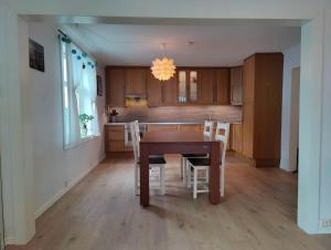 a kitchen with a wooden table and white chairs at Fløyen Townhouse in Bergen