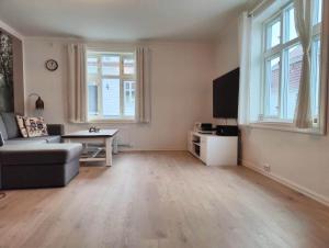 an empty living room with a couch and a tv at Fløyen Townhouse in Bergen