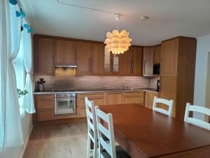 a kitchen with wooden cabinets and a table and a chandelier at Fløyen Townhouse in Bergen