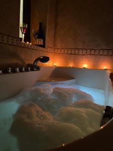 a bath tub filled with water in a bathroom at Arolithos-Kaimaktsalan in Palaios Agios Athanasios