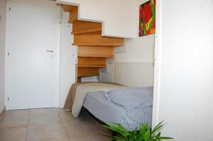 ein Schlafzimmer mit einer Treppe und einem Bett in einem Zimmer in der Unterkunft Lovely flat with swimming pool in Bibione in Bibione