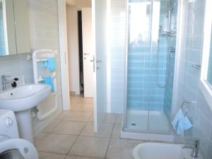 ein Bad mit einer Dusche, einem WC und einem Waschbecken in der Unterkunft Lovely flat with swimming pool in Bibione in Bibione