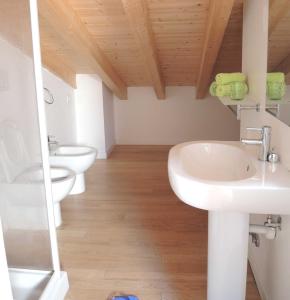 ein Badezimmer mit 2 Waschbecken und 2 WCs in der Unterkunft Lovely flat with swimming pool in Bibione in Bibione
