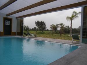 una piscina con 2 sillas y una ventana en Quinta De Azemeis en Vimieiro