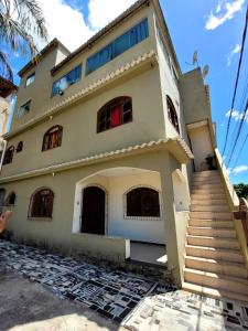 ein Haus mit Treppe davor in der Unterkunft Apartamento de 2 quartos in Piúma