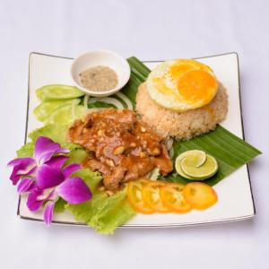 a plate of food with chicken rice and vegetables at Happy Heng Heang Guesthouse in Siem Reap