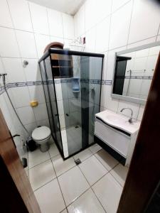 a bathroom with a shower and a toilet and a sink at Apartamento de 2 quartos in Piúma