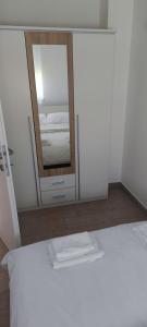 - un lit blanc dans une chambre avec un miroir dans l'établissement Apartments Rtina Benici, à Rtina