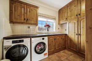 uma lavandaria com máquina de lavar e secar roupa em Gormley Residence em Cottian