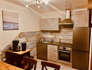 une cuisine avec un réfrigérateur en acier inoxydable et une table dans l'établissement Haus am See mit Steg, Boot, Kamin und Sauna - Mecklenburgische Seenplatte, à Blankensee