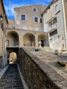 een oud gebouw met een stenen muur ervoor bij GITE chez "Chambre D'Hôtes Sandra" in Annot