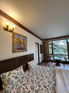 1 dormitorio con 1 cama y una pintura en la pared en Villa Bliss Lake View, en Nainital