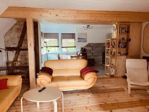 ein Wohnzimmer mit einem Sofa und einem Tisch in der Unterkunft Haus am See mit Steg, Boot, Kamin und Sauna - Mecklenburgische Seenplatte in Blankensee