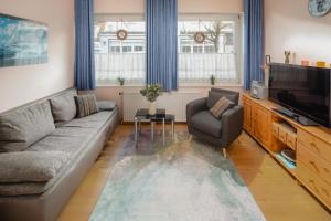 a living room with a couch and a television at Villa Marie Wohnung 1, Norderney in Norderney