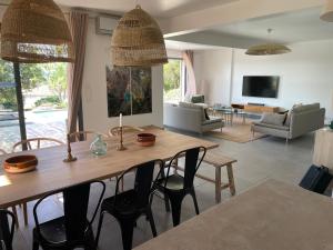 salon z drewnianym stołem i krzesłami w obiekcie Villa Terra Vecchia, 6 ou 12 personnes, vue imprenable, piscine chauffée w mieście Porto-Vecchio