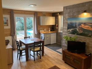 uma cozinha e sala de jantar com uma mesa e uma televisão em Appartements 2 Pièces Plage Sud à 200M em Lacanau-Océan