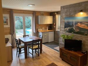 une cuisine et une salle à manger avec une table et une télévision dans l'établissement Deux pièces ou studio Plage Sud à 200m, à Lacanau-Océan