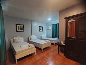 a room with two beds and a couch in it at Calicoan Villa in Sarog