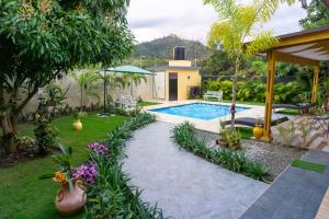 a backyard with a swimming pool and a house at Villa Rosalía Jarabacoa con Piscina Climatizada in Jarabacoa