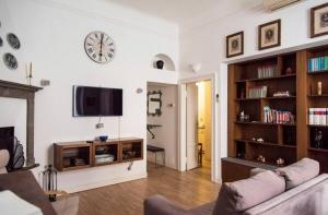uma sala de estar com um sofá e um relógio na parede em ALTIDO Classic flat near Basilica di Sant'Ambrogio em Milão