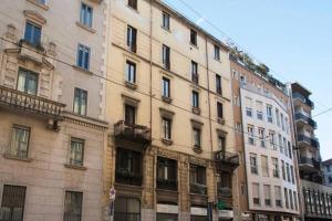 um edifício alto com muitas janelas numa cidade em ALTIDO Classic flat near Basilica di Sant'Ambrogio em Milão