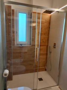 een badkamer met een douche, een toilet en een raam bij B&B Tanto Piacere Taranto in Taranto