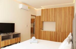 Zimmer mit einem Bett und einem TV in einem Zimmer in der Unterkunft Beautiful 1 Bedroom Aldea Zama En Tulum in Tulum