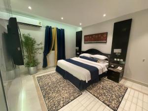 a bedroom with a bed and a potted plant at الذهبية راحتي - golden comfort in Al Thybiyah