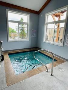 a swimming pool in a room with two windows at Come feel what it's like to relax at 4900' in Sugar Mountain
