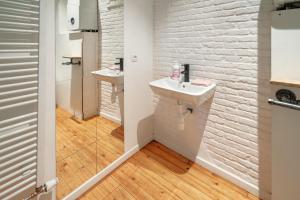 a bathroom with a sink and a white brick wall at Charming Two-Bedroom River Side Apartment in Antwerp