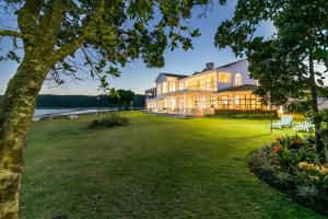 a large house with a large yard next to the water at St. James of Knysna in Knysna